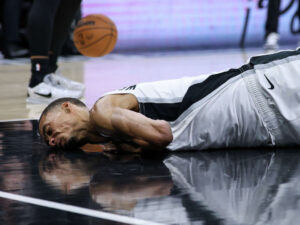 Victor Wembanyama sitting on the court looking dazed following the scary Wemby injury in Game 2 against the Trail Blazers.