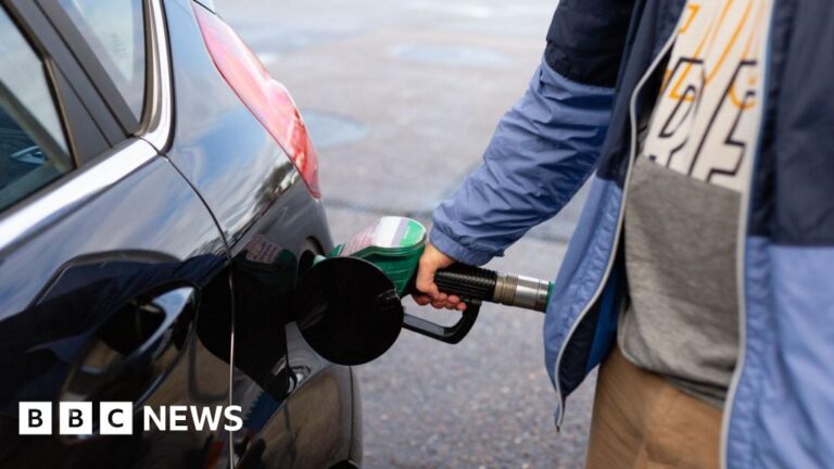 Man filling up car at petrol station, symbolizing high oil prices