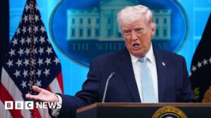 President Trump at a podium, delivering a speech during a press conference.