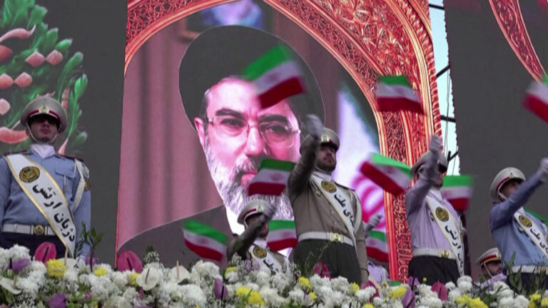 Pro-government rally in Tehran demanding an end to US threats and the blockade of Iranian ports, with crowds gathered.