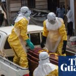 Health workers in yellow protective suits prepare to transport an Ebola victim's body in Bunia, DRC, highlighting the severity of the Ebola outbreak DRC.