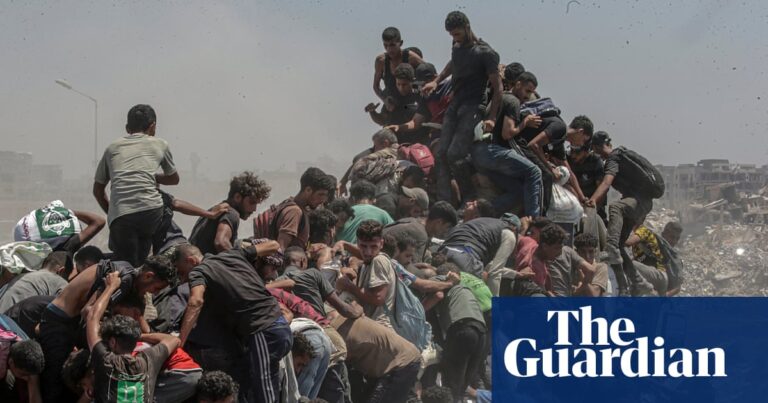Image of displaced Palestinians jostling for aid from a truck in Gaza, highlighting the desperation amidst food shortages.