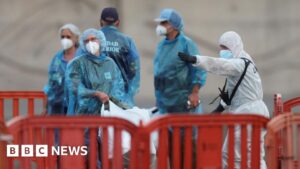 Cruise ship passengers disembarking in Tenerife wearing protective gear.