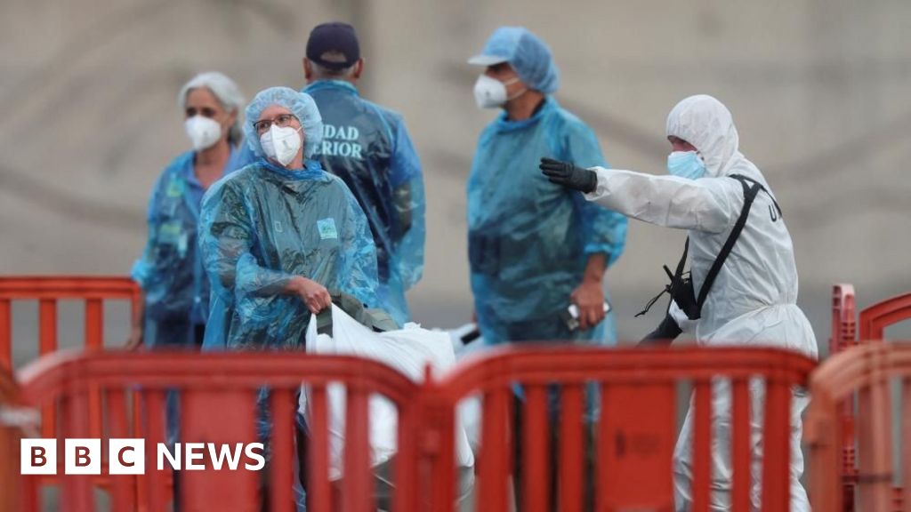 Cruise ship passengers disembarking in Tenerife wearing protective gear.