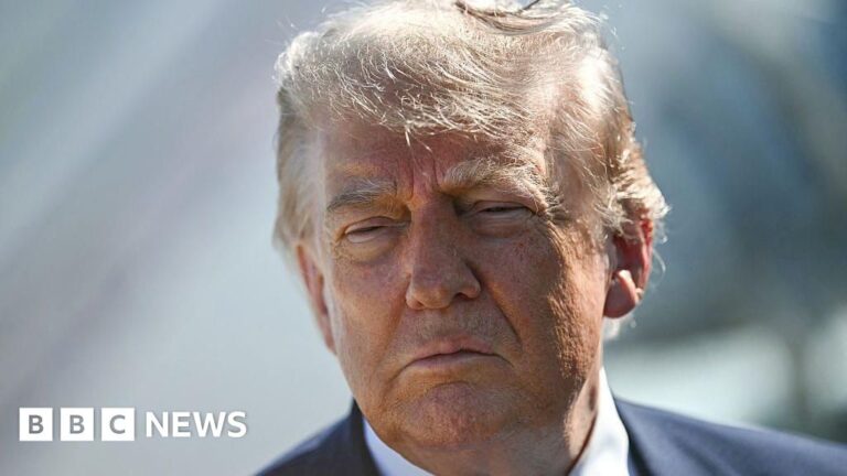 Donald Trump looking at the camera in a suit, suggesting a serious political discussion.