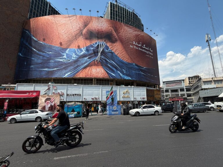 Billboard in Tehran showing Strait of Hormuz and sewn lips of Donald Trump as tensions rise over Iran Plan.