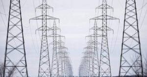 Image of Manitoba Hydro power lines against a stormy sky, indicating widespread power outages due to severe weather.