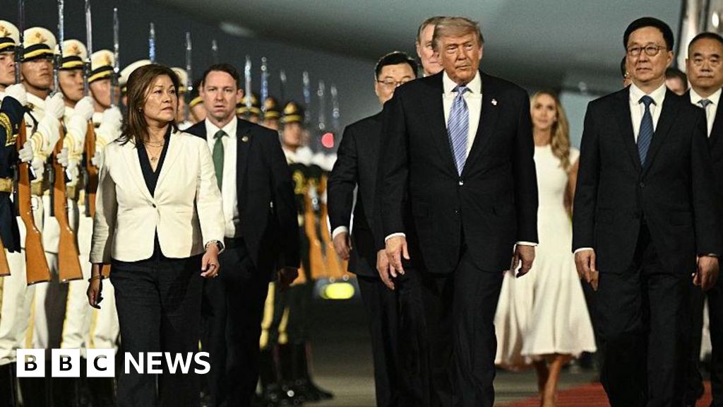 US President Donald Trump disembarks Air Force One in Beijing, greeted by Chinese officials and a ceremonial guard.