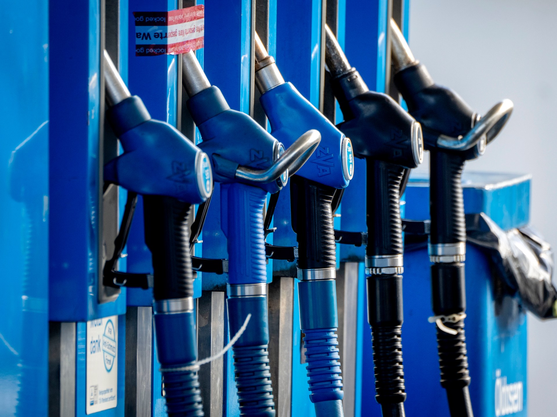 Pumps at a gas station with a headline about UAE increasing oil supplies.