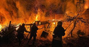 Ukrainian rescue workers extinguishing a fire in a residential building destroyed by a Russian drone strike in Odesa, Ukraine.