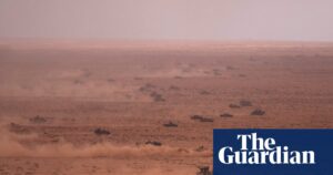Image shows military vehicles in a desert kicking up dust, representing the harsh terrain of the African Lion exercise.