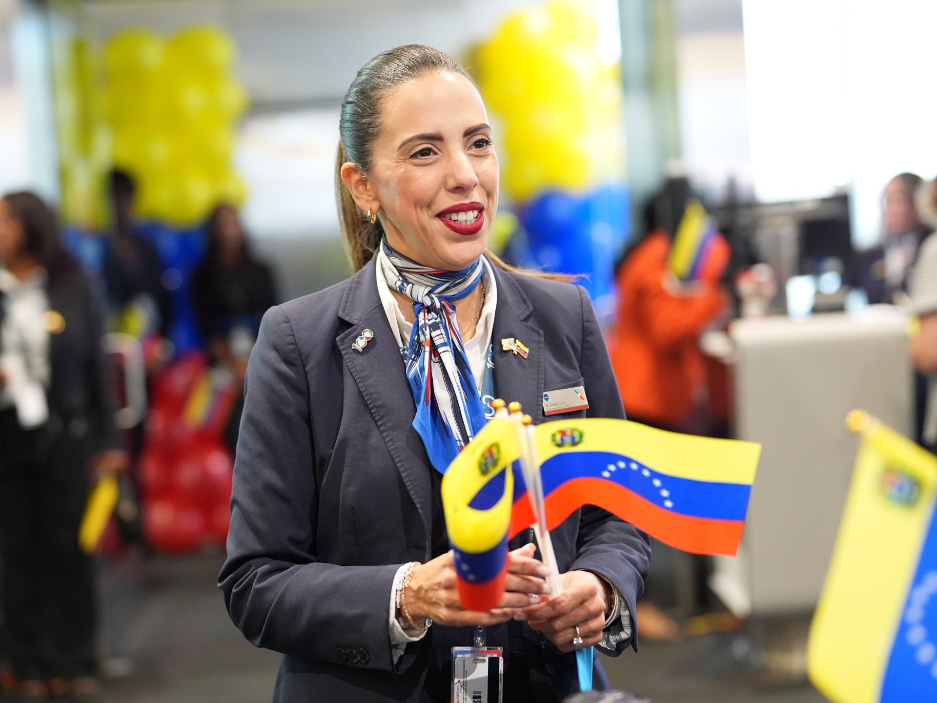 American Airlines agent holding Venezuelan flags to pass out to passengers for Flight AA3599, the first direct commercial flight between the United States and Venezuela.
