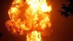 A large fire burning in a building in Delhi's Vijay Vihar area at night, with emergency services on site.