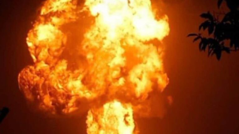 A large fire burning in a building in Delhi's Vijay Vihar area at night, with emergency services on site.