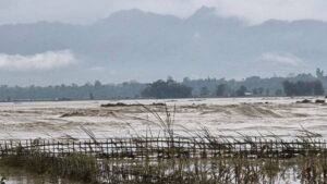 Image showing flooded areas in Assam with a railway bridge damaged.