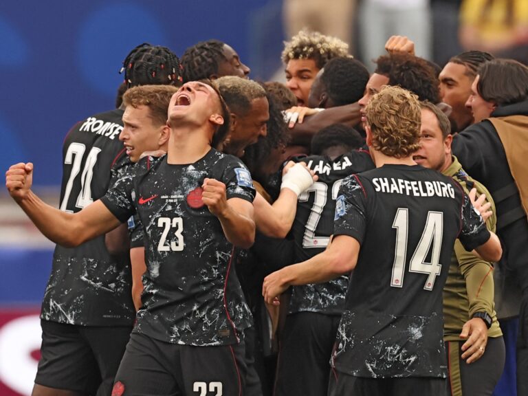 Image of Canadian players celebrating a last-minute goal in a World Cup match.