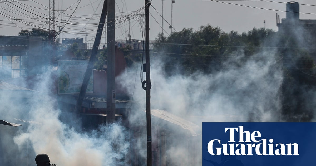 Riot police and armed officers amidst teargas smoke and debris during protests against an Ebola quarantine center in Nanyuki, Kenya.