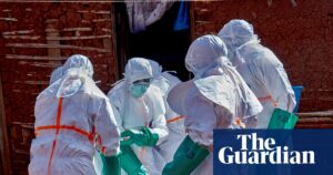 People in hazmat suits retrieve a body of an Ebola victim in DRC.
