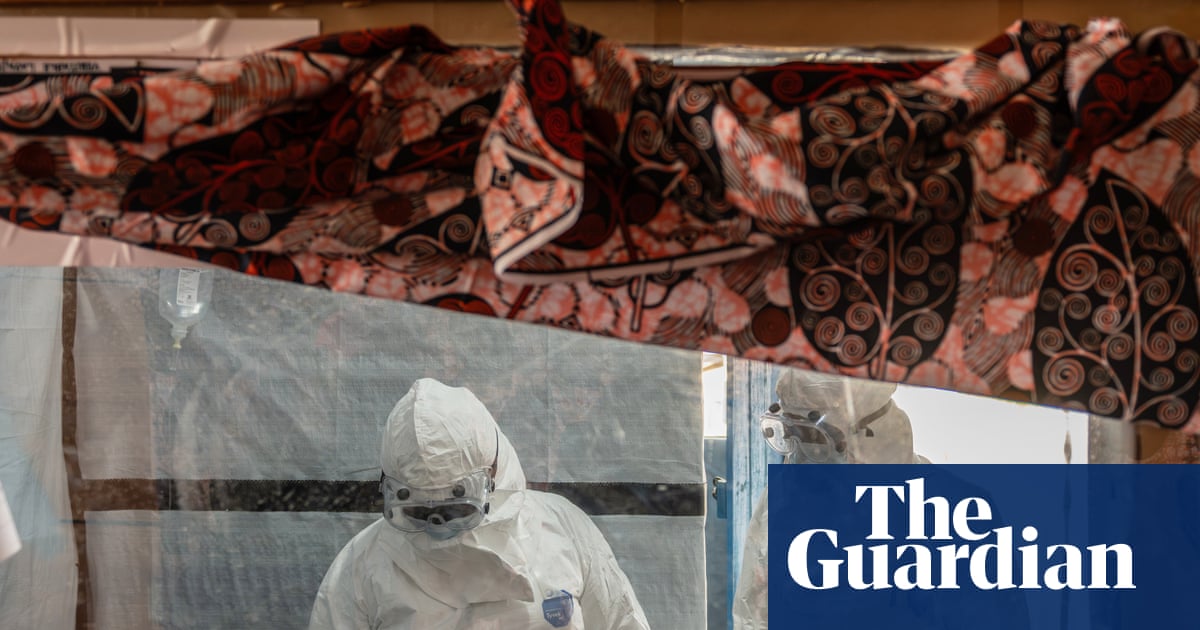 Health workers in hazmat suits tend to a patient, symbolizing the fight against Ebola.