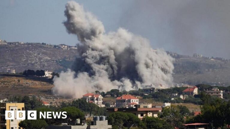 Aerial view of southern Lebanon after Israeli strikes, showing smoke rising from damaged buildings.