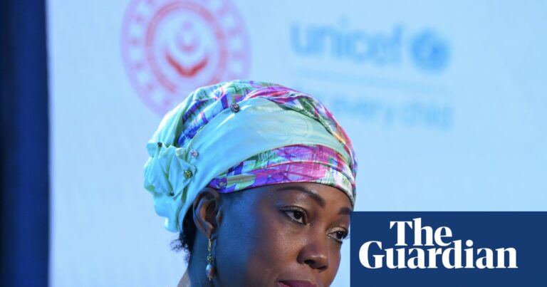 Sierra Leone's First Lady, Fatima Maada Bio, speaking into a microphone. This image illustrates the news about her controversial stance on FGM.