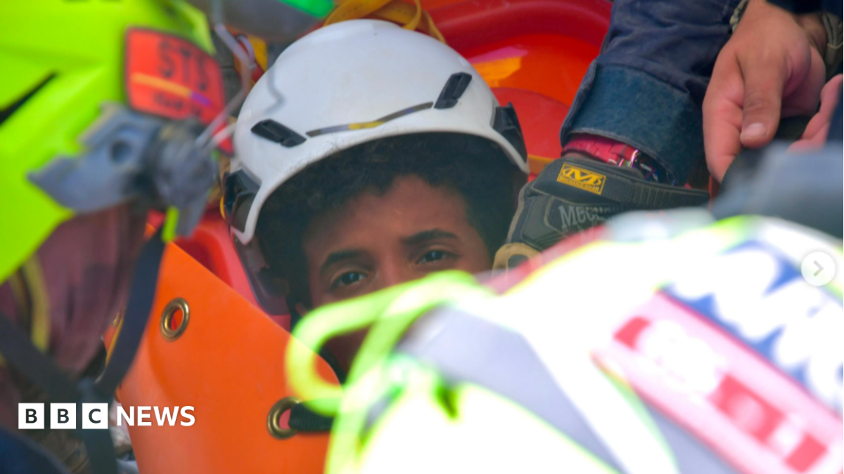 Rescue workers pulling a boy from earthquake rubble in Venezuela, illustrating hope and resilience.