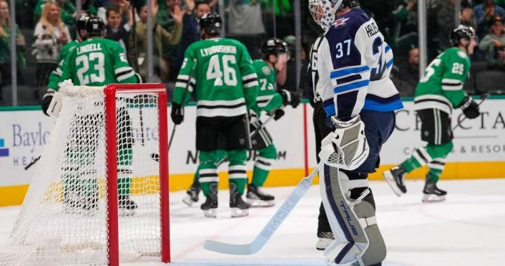 Winnipeg Jets goaltender Connor Hellebuyck looks down at the ice.