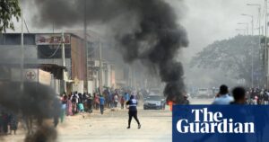 A street scene with a burning log in the foreground and protesters, representing the Angolan fuel price riots.