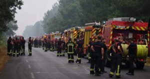 Image of firefighters waiting on a road near Lacanau, southwestern France, surrounded by smoke and haze from the large-scale European wildfires.