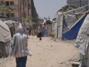 Displaced Palestinians walk amidst tents in Deir al-Balah, Central Gaza.