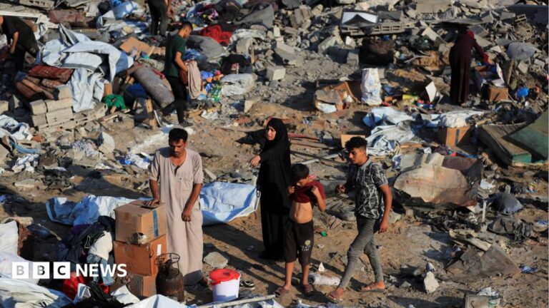 Palestinians inspect a destroyed house in Gaza City after an Israeli strike