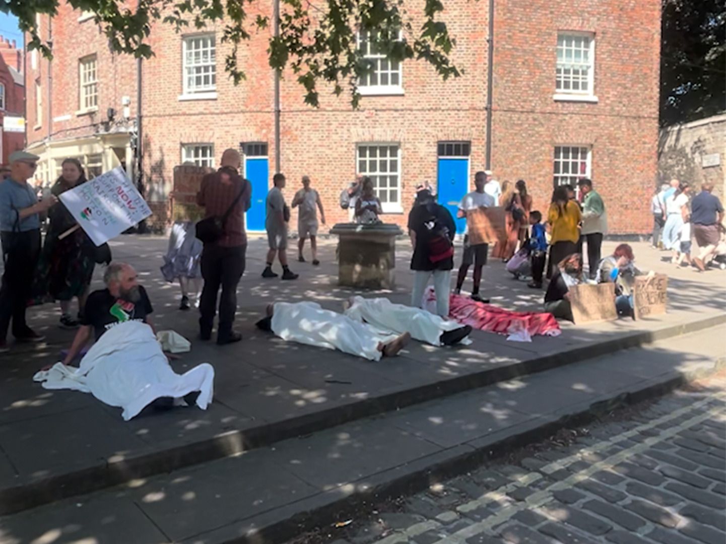UK Christians protest calling for the Church of England to recognize genocide in Gaza, holding banners.