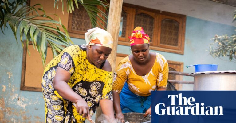 Two African women cooking outdoors, representing food preparation amidst global challenges.