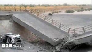Image of a damaged bridge in Iran after a US airstrike, showing rubble and broken concrete.