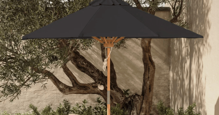 A vibrant yellow patio umbrella providing generous shade over an outdoor seating area.