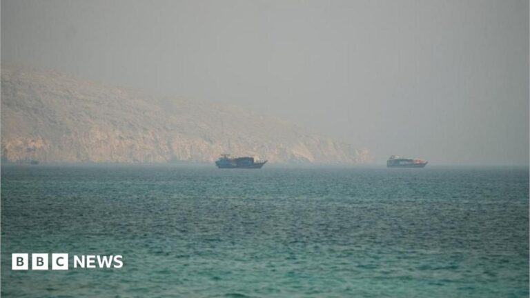 Image showing the Strait of Hormuz with commercial vessels navigating past rocky mountains