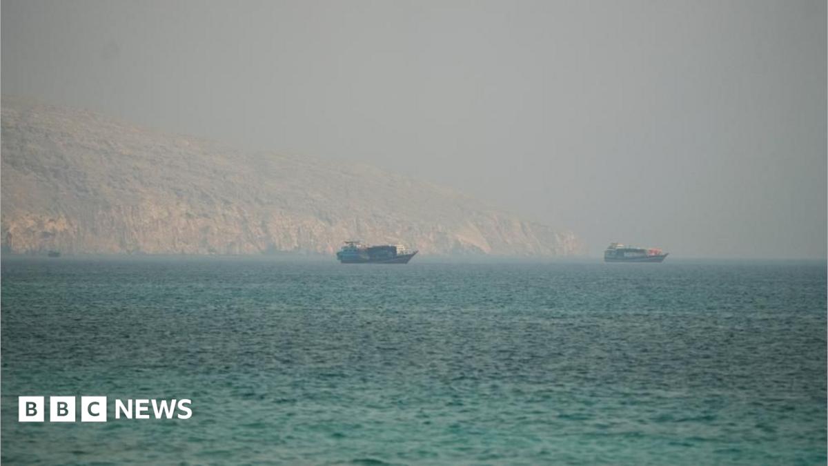 Image showing the Strait of Hormuz with commercial vessels navigating past rocky mountains