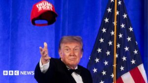 President Trump addressing reporters at the White House Correspondents' Dinner with a mischievous expression.