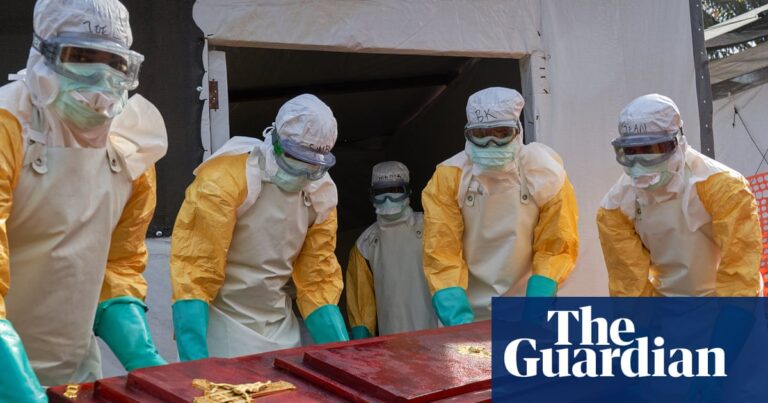 Four people in protective gear carrying a coffin for an Ebola victim in Democratic Republic of Congo.