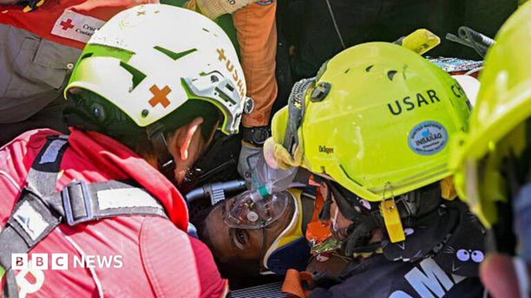Heroic rescue worker looking at trapped survivor in rubble