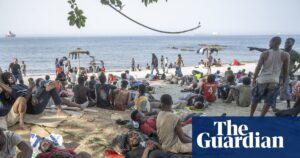 People rest on a beach under the supervision of Guardia Civil officers in Ceuta, highlighting the Ceuta border crisis.