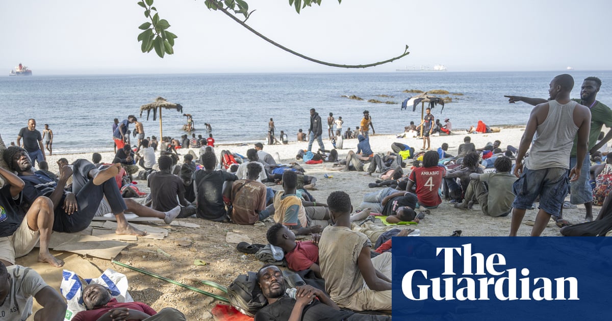People rest on a beach under the supervision of Guardia Civil officers in Ceuta, highlighting the Ceuta border crisis.