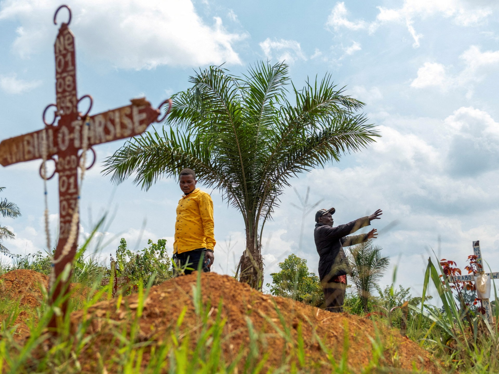 Cemetery supervisor and assistant warden at a gravesite in Ebola-ravaged Mungwalu, Ituri province, northeastern Democratic Republic of Congo.