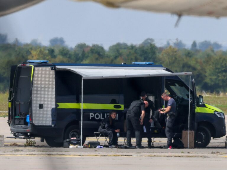 Image of drone near airport runway, illustrating European drone incursions and the new level of danger. Police officers examining a drone near an Antonov cargo plane at Leipzig/Halle Airport.