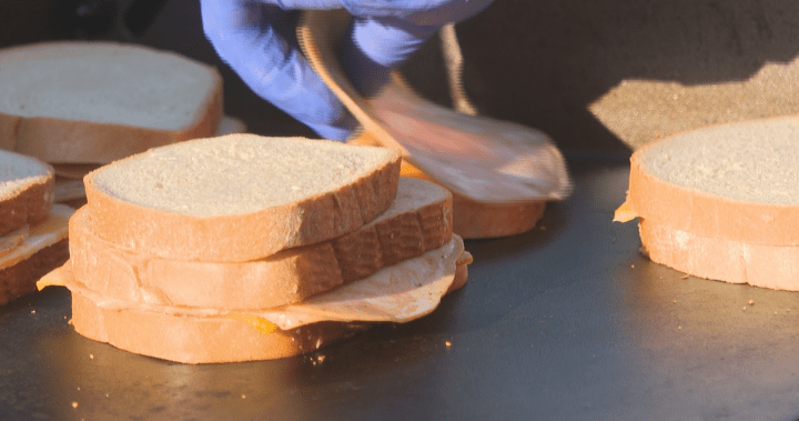 Sean Espinoza preparing grilled cheese sandwiches for homeless individuals in Toronto, demonstrating community outreach and support for those in need.