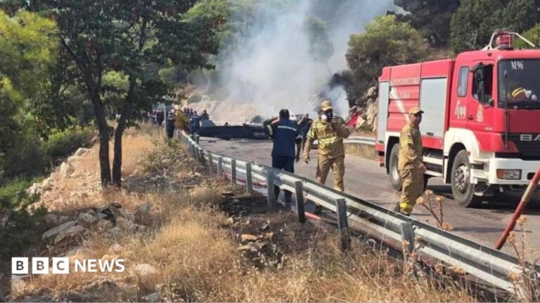 Firefighters and forensic experts investigate the crash site of two helicopters after a mid-air collision in Greece.
