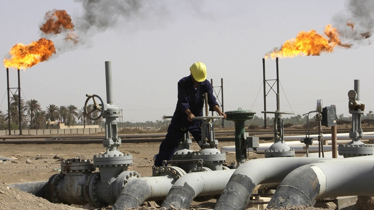 Iraqi worker maintaining an oil pipe at Nahr al-Umran gas refinery in Iraq