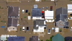 Aerial view of flooded streets in Japan's Chiba region with abandoned cars.