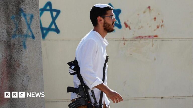 Israeli settlers move into Kadim settlement in the West Bank, carrying supplies and flags.