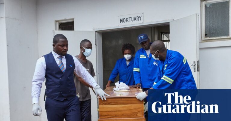 Image of four men and a woman rolling a coffin out of a mortuary after the Lake Kariba ferry disaster.